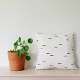 Black and white artisanal hand-painted hemp linen nordic scandinavian  kamppinen birch pattern 18" square pillow on bench with plant